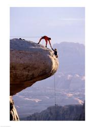 Side profile of a young man pulling a young woman onto a rock | Obraz na stenu