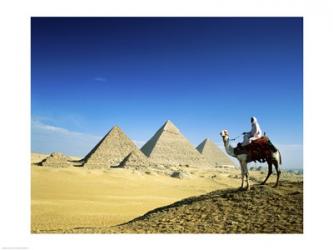 Man riding a camel near the pyramids, Giza, Egypt | Obraz na stenu
