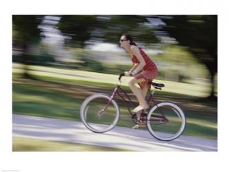 Side profile of a young woman riding a bicycle | Obraz na stenu