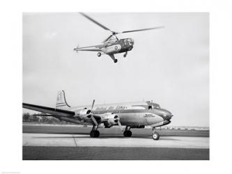 Low angle view of a helicopter in flight and an airplane at an airport, Sikorsky Helicopter, Douglas DC-4 | Obraz na stenu