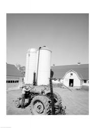 USA, Farmer Working on Tractor, Agricultural Buildings in the Background | Obraz na stenu