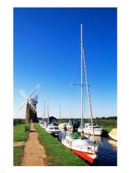 Boats moored near a traditional windmill, Horsey Windpump, Horsey, Norfolk Broads, Norfolk, England | Obraz na stenu