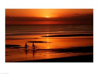Silhouette of a young couple cycling on the beach | Obraz na stenu