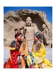 Two girls in traditional costumes in front of the Buddha Statue, China | Obraz na stenu