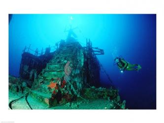 Scuba diver watching a shipwreck underwater | Obraz na stenu