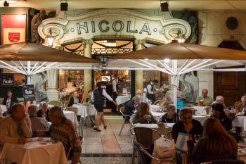 Lisbon, Portugal. Clients at pavement tables of the famous Nicola cafe on the Rossio. Evening. | Obraz na stenu