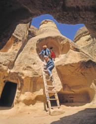 Tourists exploring cave houses (photo) | Obraz na stenu