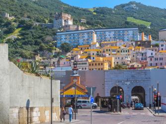 Gibraltar. The Tower of Homage of the Moorish castle rising behind apartment blocks of Gibraltar town and Grand Casemates Gate which leads into Casemates Square. (photo) | Obraz na stenu