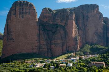 Village of Riglos beneath the conglomerate rock formations of the Mallos de Riglos, Huesca Province, Aragon, Spain. The Mallos de Riglos are approximately 300 meters high. The area is popular with climbers. (photo) | Obraz na stenu