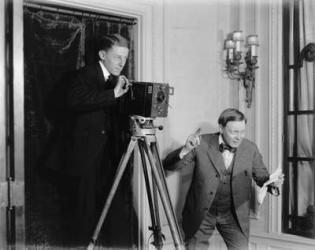 Two men using a movie camera indoors, c.1908-20 (b/w photo) | Obraz na stenu