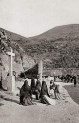 Women kneeling in front of cross in a roadside scene in Spain circa 1900 | Obraz na stenu