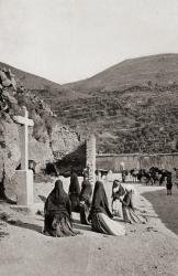 Women kneeling in front of cross in a roadside scene in Spain circa 1900 | Obraz na stenu